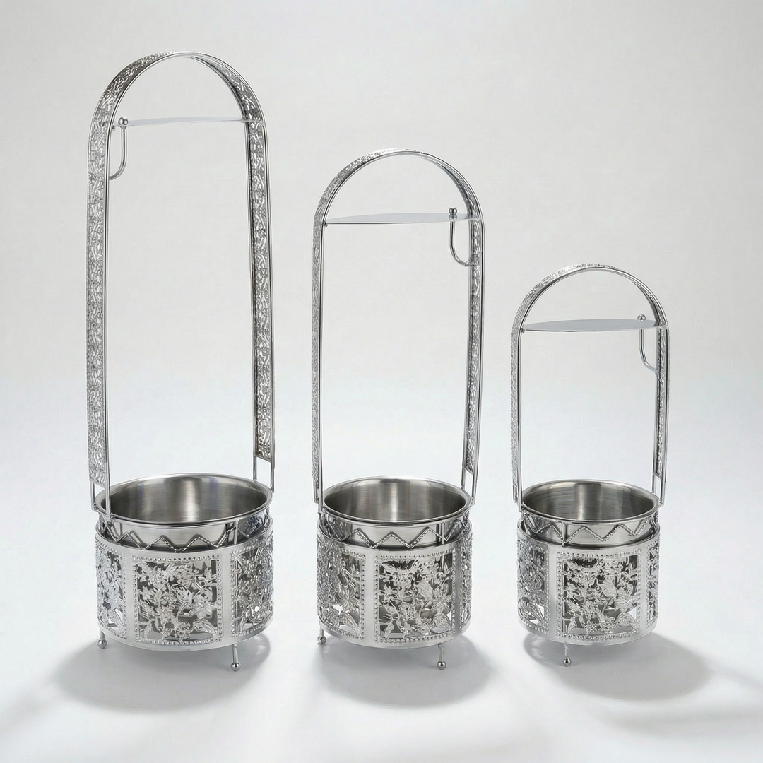Basha Buzz charcoal carrier in silver, ornate open basket with a steel bowl inside and a tall arch handle, shown in 3 sizes