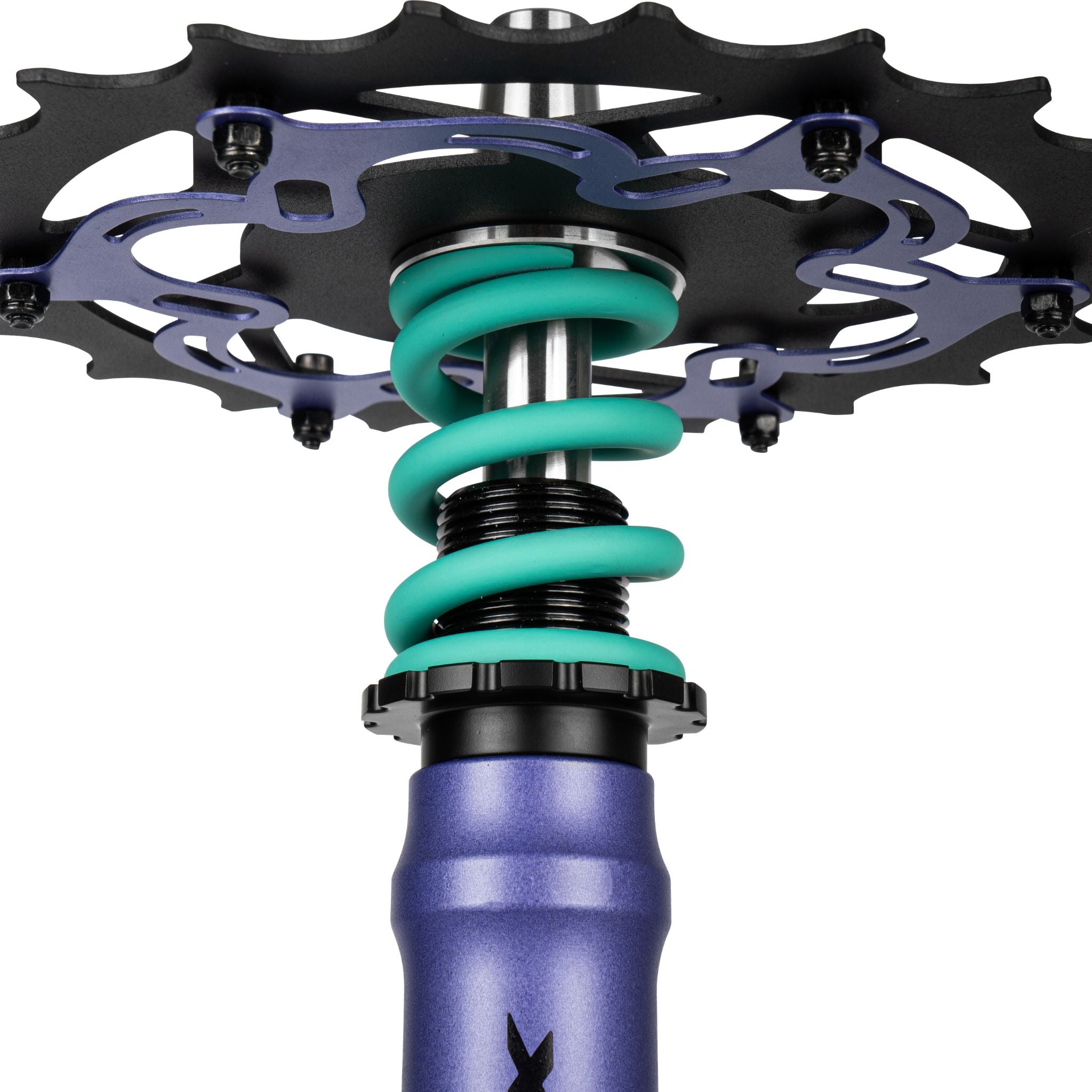 Amotion Pedal RX Grape chainring underside close-up — purple bike-style cog over the teal coil spring and stem