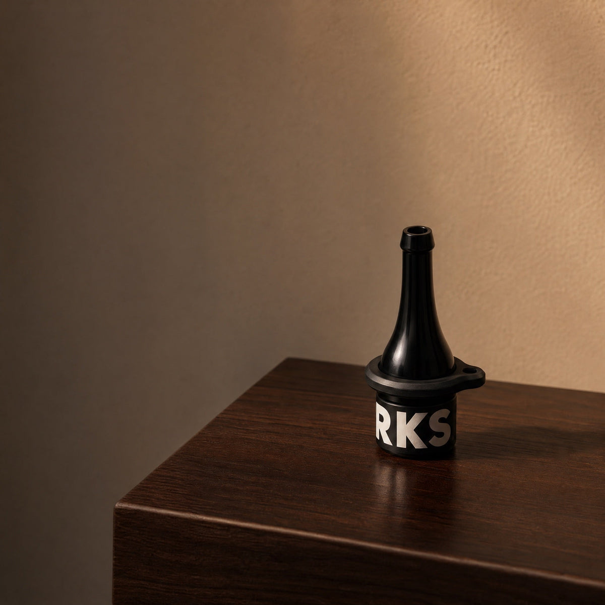 Darkside D-Stick Base mouthpiece on dark walnut console at twilight, warm directional light, lifestyle hero, image 4 of 7