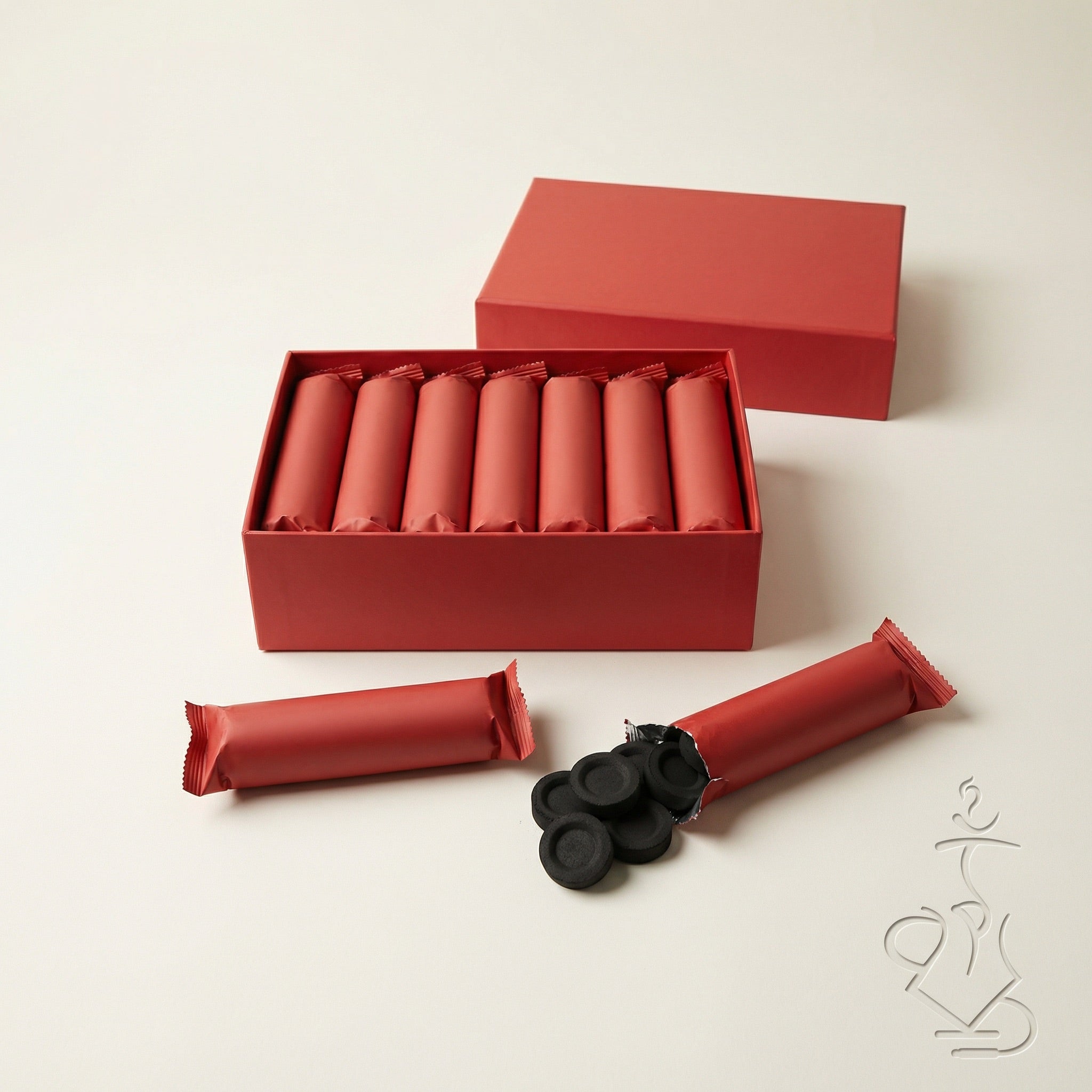 Essentials Quick-Light Charcoal 33mm box opened from above showing foil sleeves packed inside plus loose tablets spilled from an open sleeve in a flat lay.