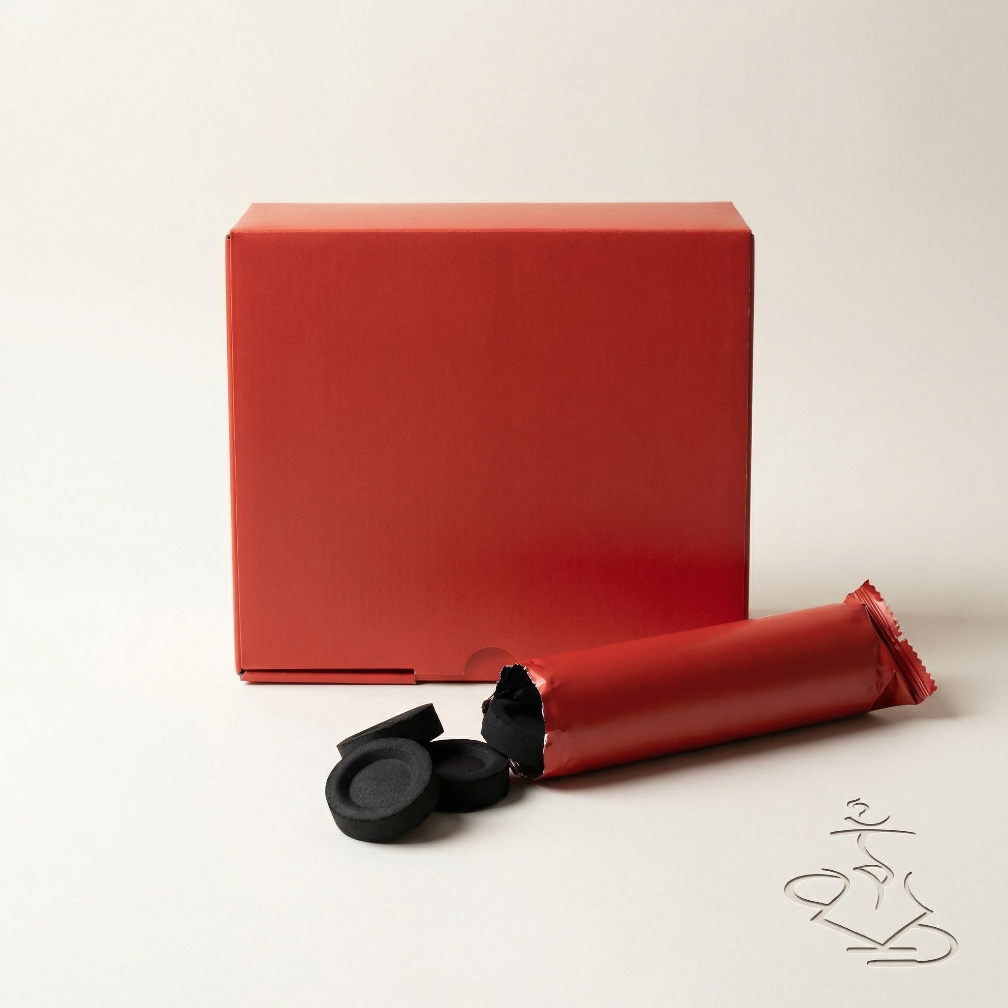 Essentials Quick-Light Charcoal 33mm retail box with an open foil sleeve and loose matte black charcoal tablets spilled in front on a warm studio background.