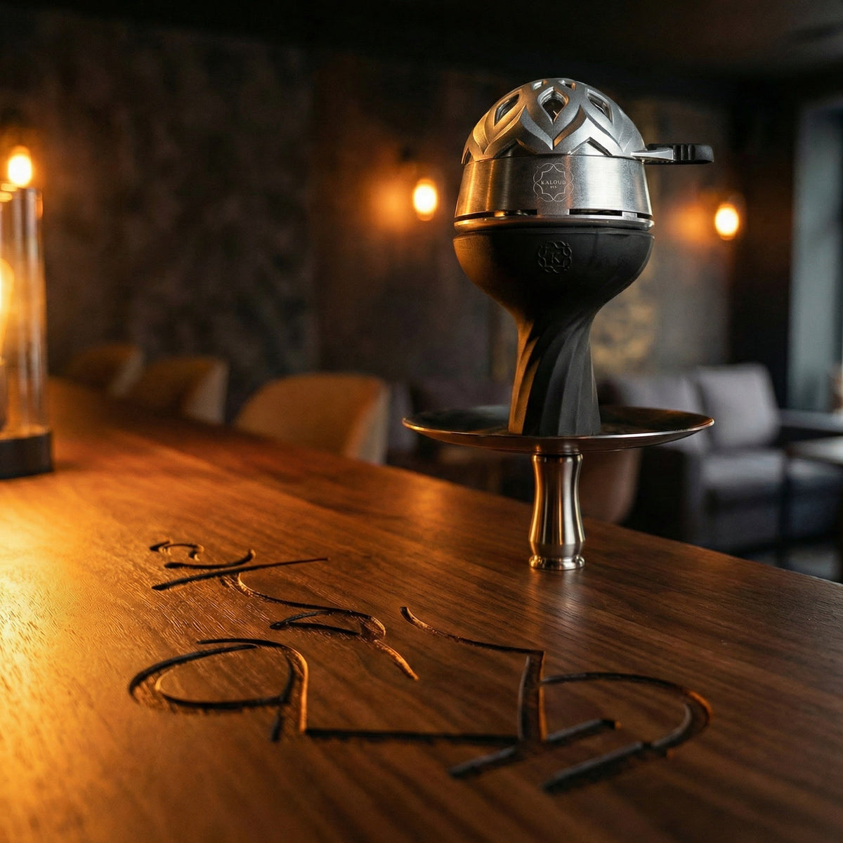 Kaloud Lotus I+3 Argis Silver HMD mounted on a premium hookah in a warm lounge setting, styled as an aspirational session centrepiece on a walnut bar top., image 15 of 19