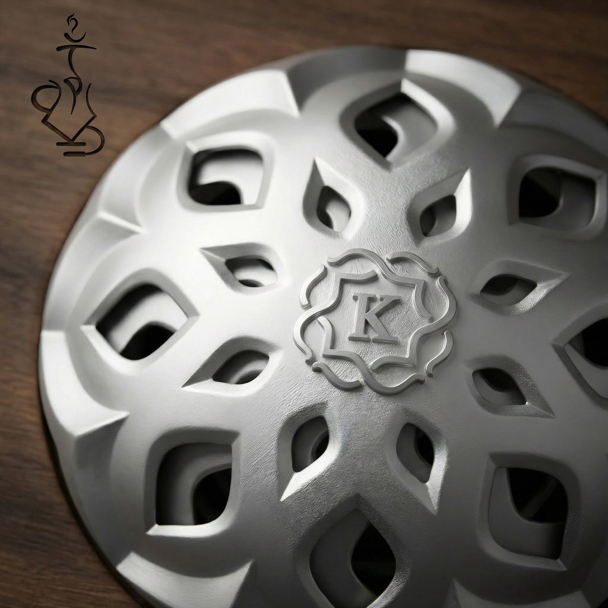 Macro top-down detail of the Kaloud Lotus I+3 Argis Silver lid, showing the ornate lotus-petal cutout pattern and central Kaloud K crest in brushed aluminium., image 18 of 19