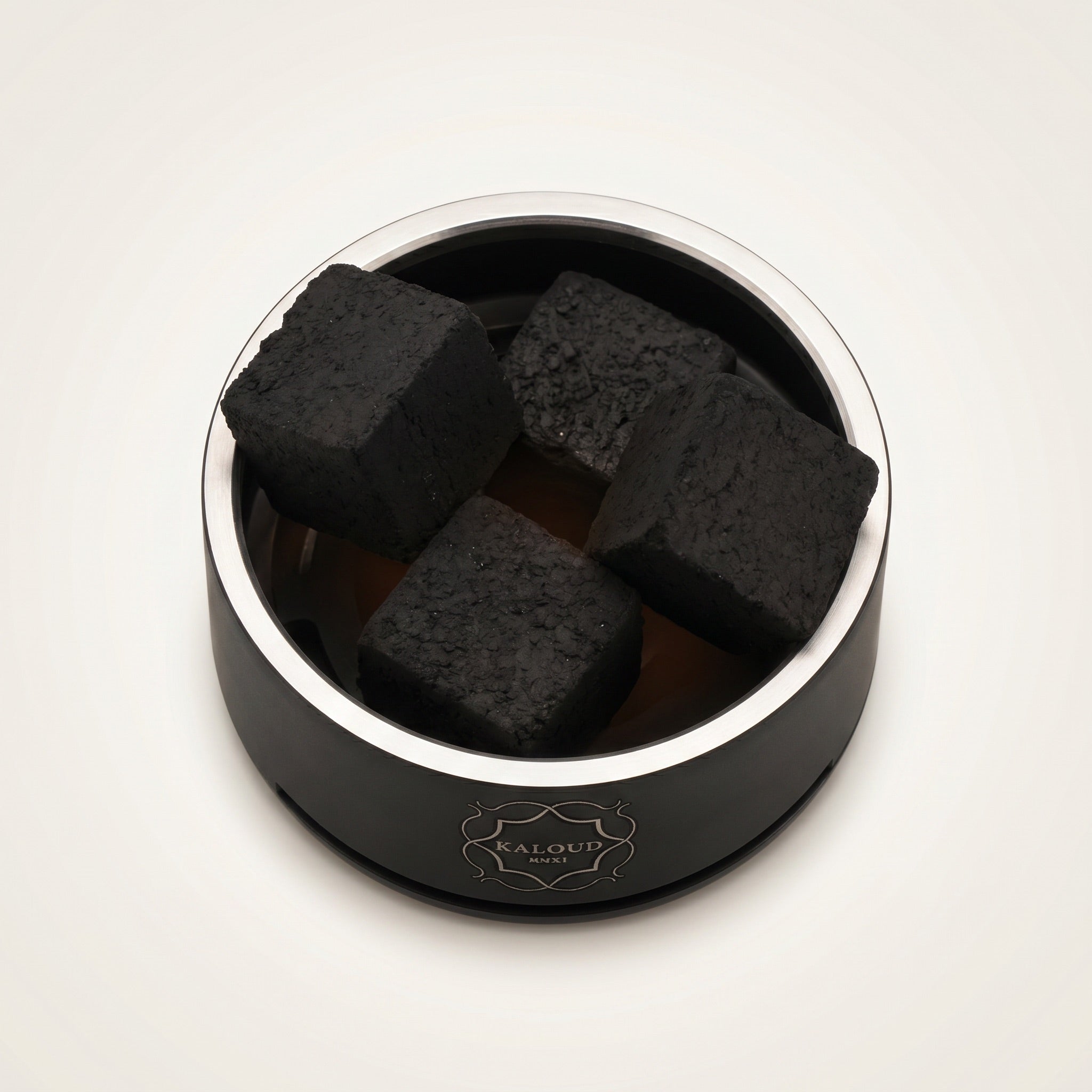 Top-down view of Kaloud Lotus I+3 Niris Black HMD chamber holding four large coconut coals