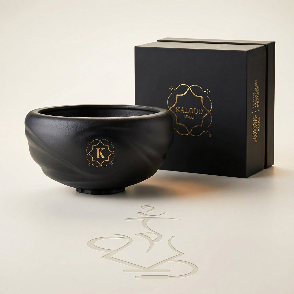 Kaloud Samsaris Kore Qì Short black clay shisha bowl with premium black-and-gold Kaloud presentation box on a warm white studio background, image 4 of 12