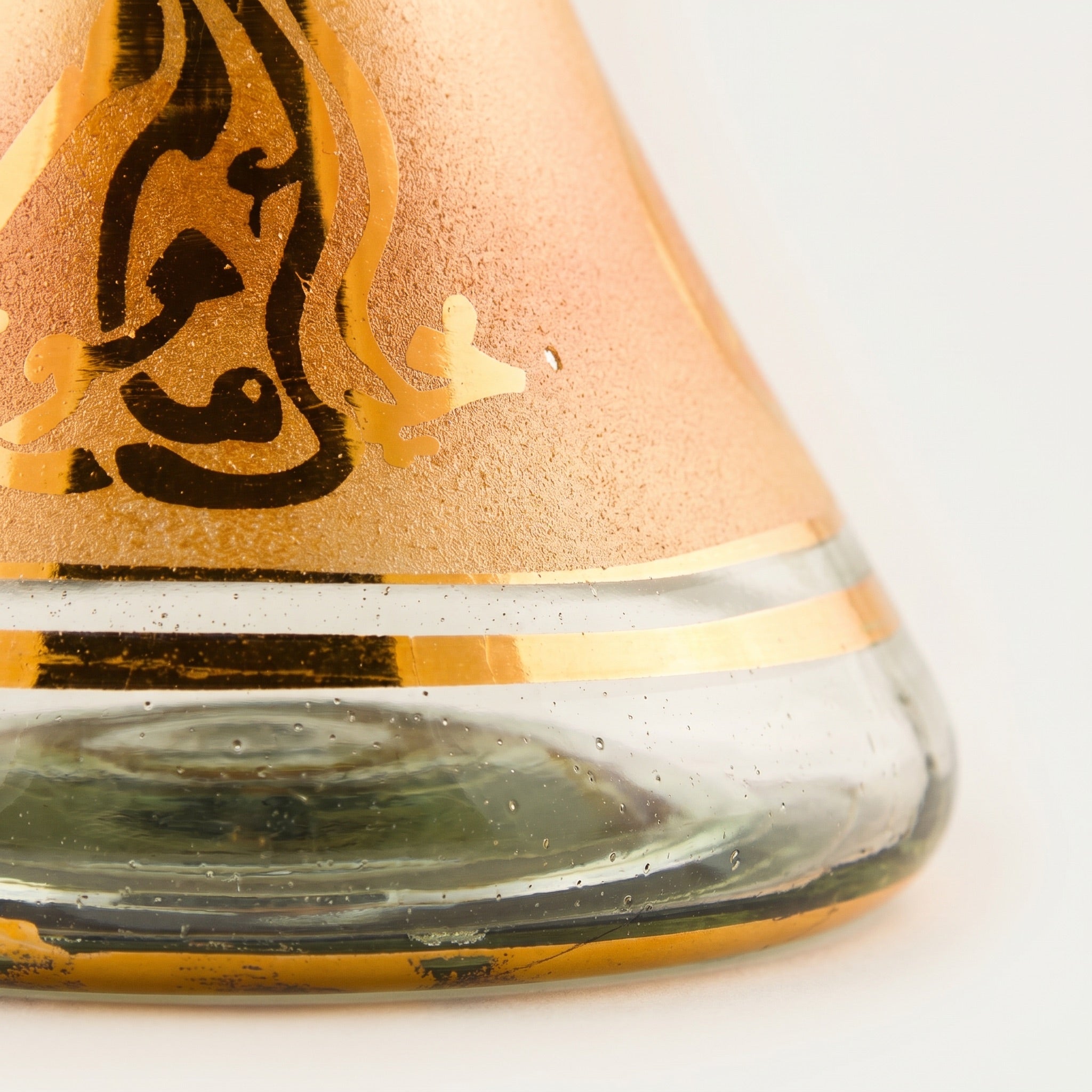 Macro detail of Khalil Mamoon Amber Gold base showing hand-painted silk-screen texture and seed bubbles.