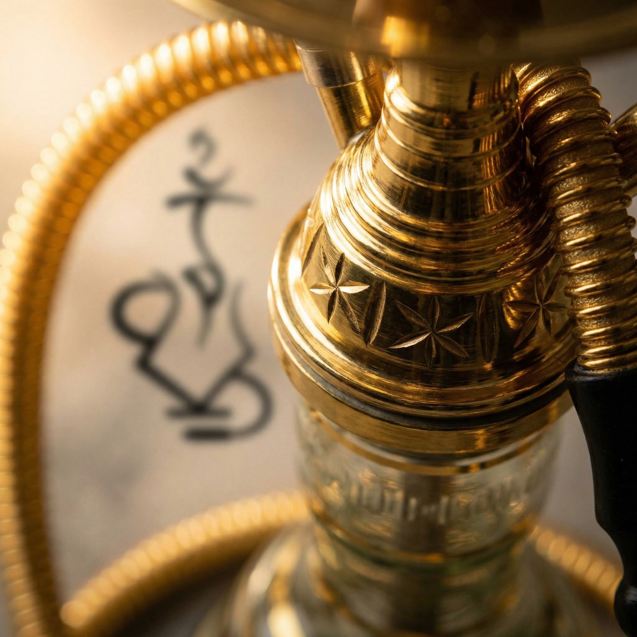 Macro close-up of the Khalil Mamoon Mini Beast Gold stem hub showing the hand-engraved star safari pattern, ridged gold tiers, and genuine handmade Cairo workshop craftsmanship.