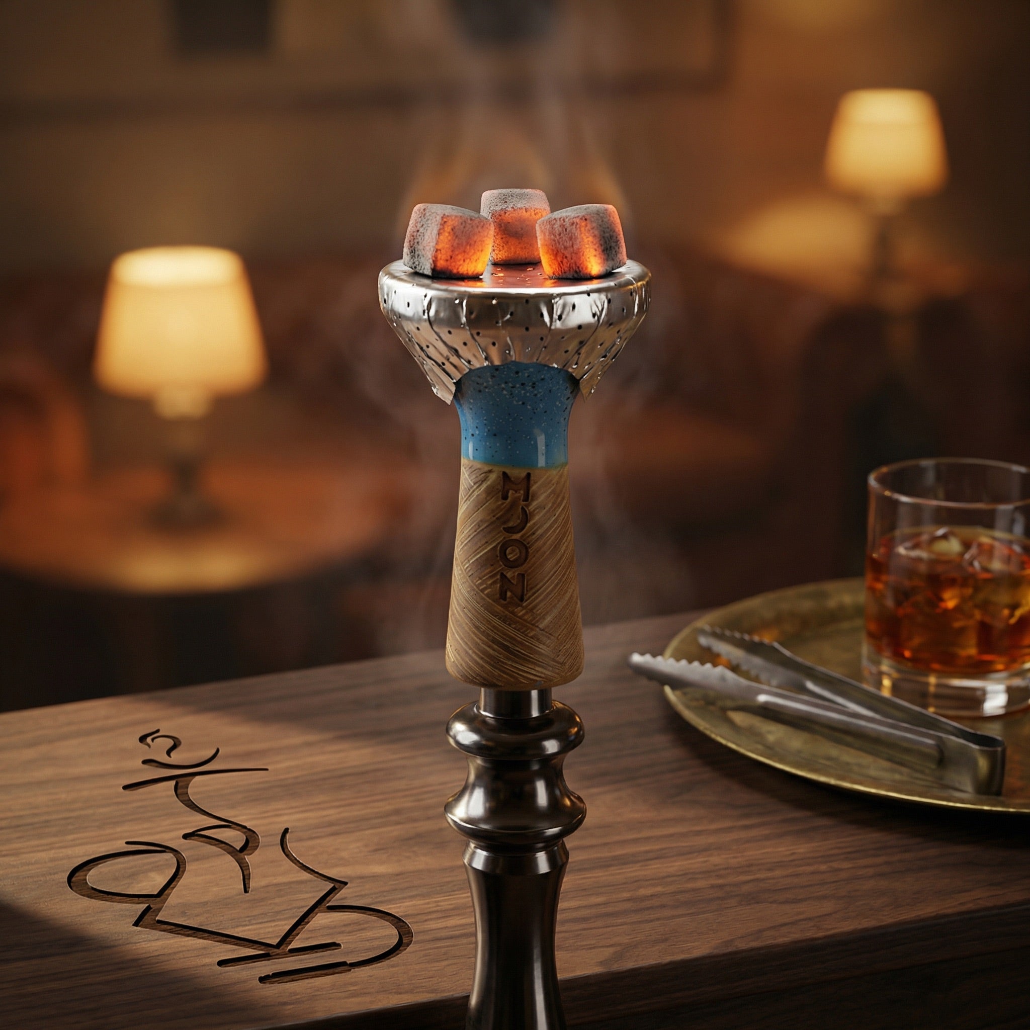 Hand using metal tongs to place a glowing coconut coal onto foil over a Moon Phunnel blue glazed bowl mounted on a hookah, captured in a warm lounge setting.