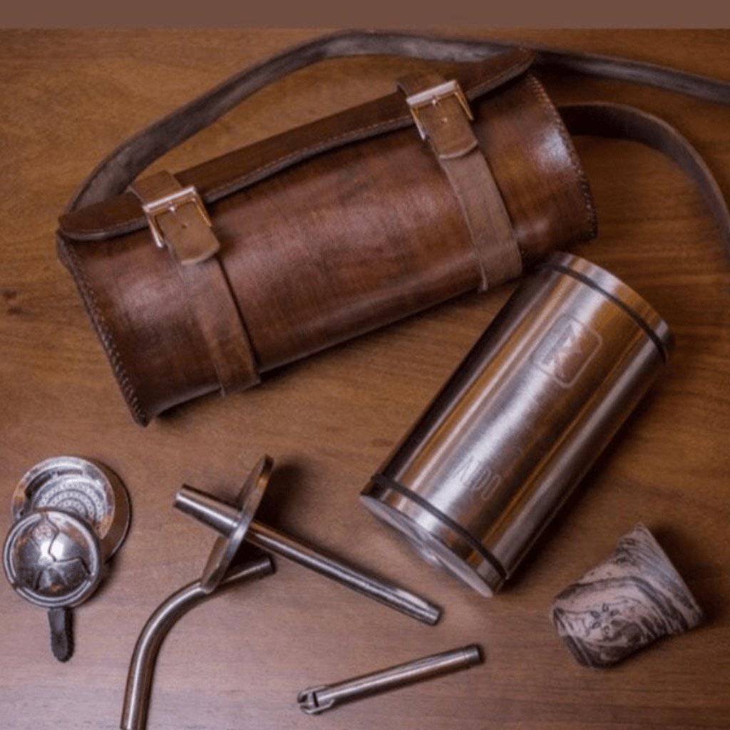 VZ Hookah Raido travel bag in brown leather, a round case with two buckle straps and a shoulder strap, side view, image 2 of 3