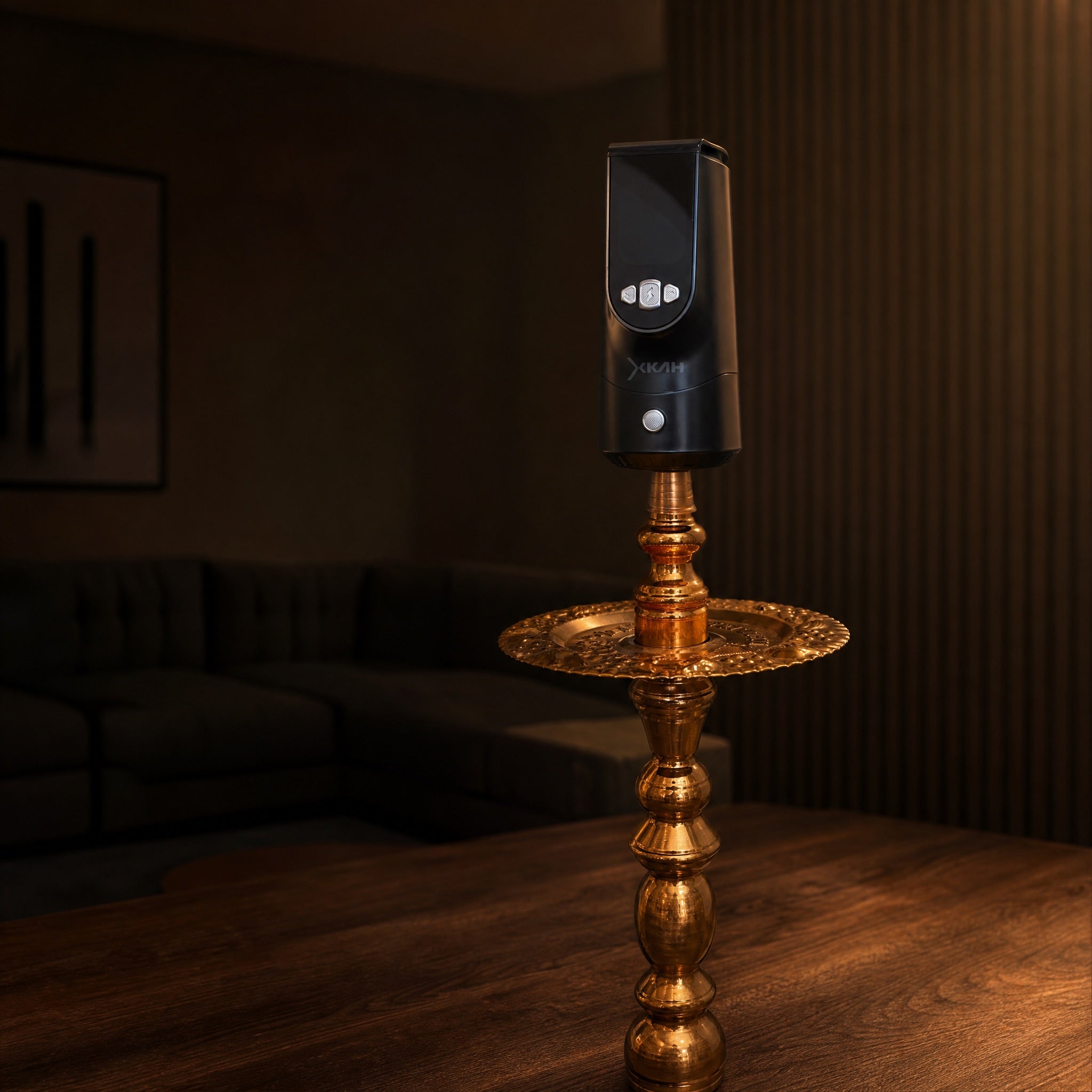 XKAH Pro mid-session on a traditional brass shisha, evening room dimmed deep into the ritual, display glowing cool.
